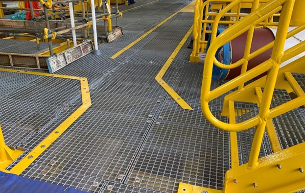 Anti-slip FRP walkway with safety yellow railings on an offshore platform